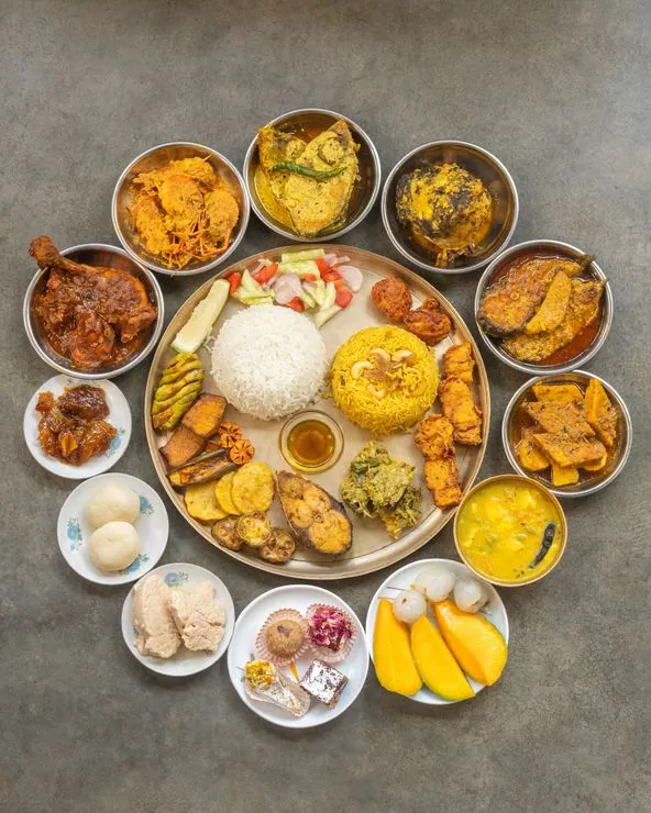 Authentic Bengali wedding buffet menu display by Food Chakra catering services, featuring traditional curries, dals, and vegetable dishes served in elegant copper handis at a venue in Kolkata. | Image for Food Chakra – Trusted Catering Services in Kolkata