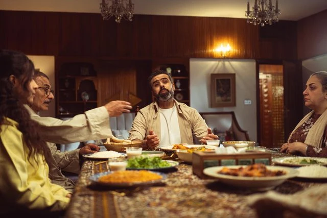 A family gathering together at a beautifully set dining table, enjoying a warm, traditional meal with multiple platters of rice and curries. This warm dining experience represents the premium family gathering and private party catering services in Kolkata by Food Chakra.
